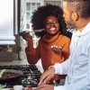 a man and a woman cooking on a gas stove top